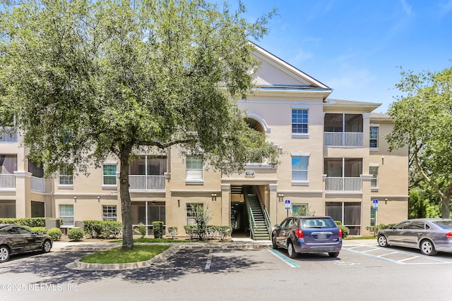 8601 Beach Blvd Unit 1202, Jacksonville, FL 32216 - view of building exterior with uncovered parking and stairs