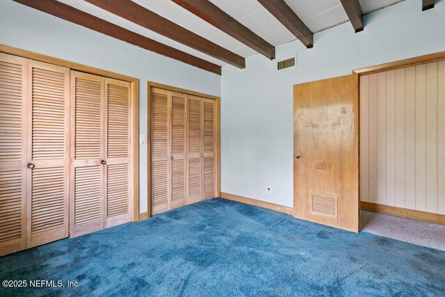 45121 Stratton Rd, Callahan, FL 32011 - unfurnished bedroom featuring visible vents, beamed ceiling, carpet floors, and multiple closets