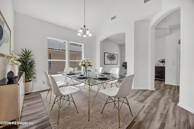 1829 Creekview Dr, Green Cove Springs, FL 32043 - dining area with arched walkways, wood finished floors, visible vents, and an inviting chandelier