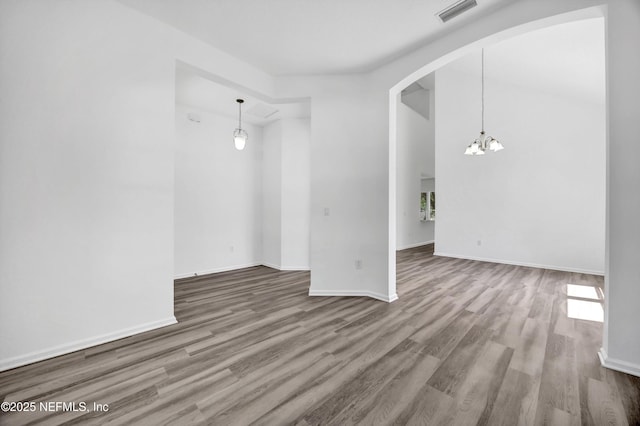 1829 Creekview Dr, Green Cove Springs, FL 32043 - empty room with wood finished floors, plenty of natural light, arched walkways, an inviting chandelier, and visible vents