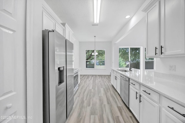 1829 Creekview Dr, Green Cove Springs, FL 32043 - kitchen with white cabinets, a sink, light wood-type flooring, appliances with stainless steel finishes, and hanging light fixtures