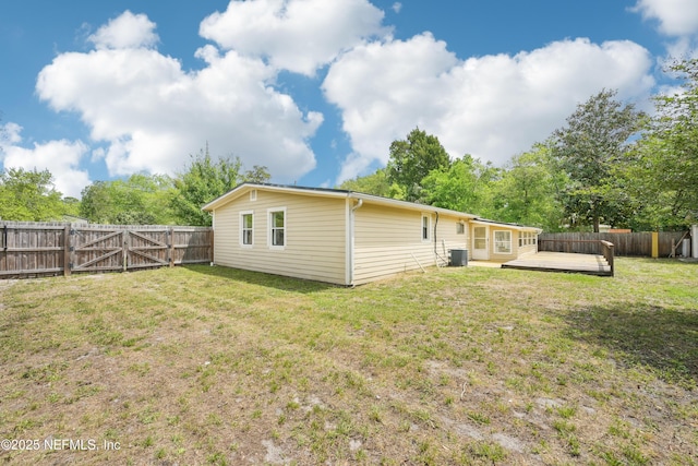 12054 Correa Ct, Jacksonville, FL 32246 - back of property with a fenced backyard, a wooden deck, central air condition unit, and a yard