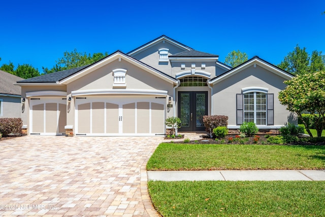 920 Gallier Pl, Jacksonville, FL 32259 - view of front facade with decorative driveway, a front lawn, french doors, a garage, and stucco siding