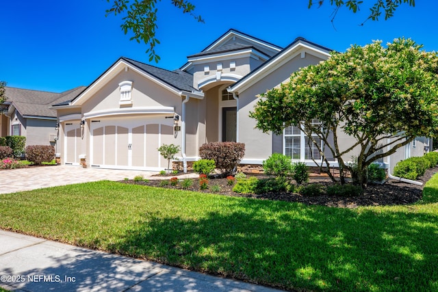 920 Gallier Pl, Jacksonville, FL 32259 - ranch-style home with an attached garage, a front lawn, decorative driveway, and stucco siding