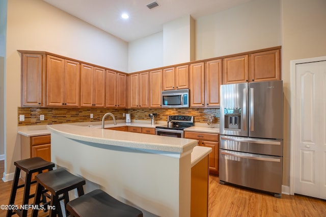 920 Gallier Pl, Jacksonville, FL 32259 - kitchen featuring light wood finished floors, stainless steel appliances, visible vents, light countertops, and a breakfast bar area