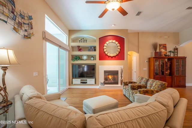 920 Gallier Pl, Jacksonville, FL 32259 - living room with arched walkways, built in shelves, wood finished floors, ceiling fan, and a fireplace