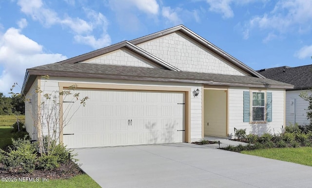 view of front of home featuring an attached garage, driveway, and roof with shingles