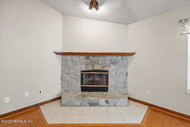 details with baseboards, a textured ceiling, and a fireplace