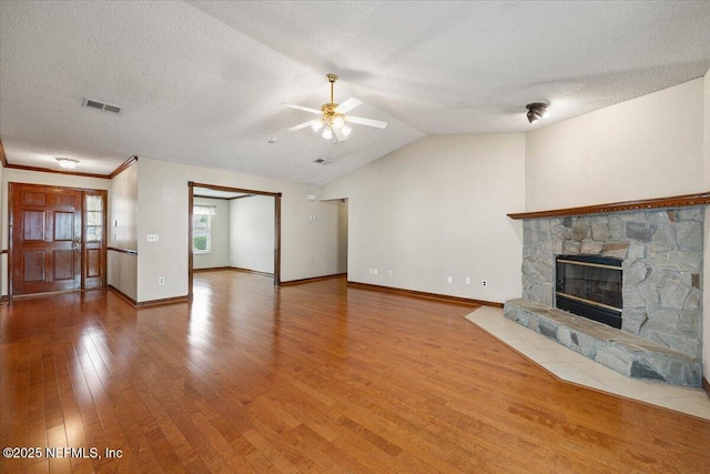 unfurnished living room with vaulted ceiling, baseboards, visible vents, ceiling fan, and wood-type flooring