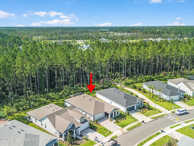 bird's eye view featuring a residential view and a wooded view