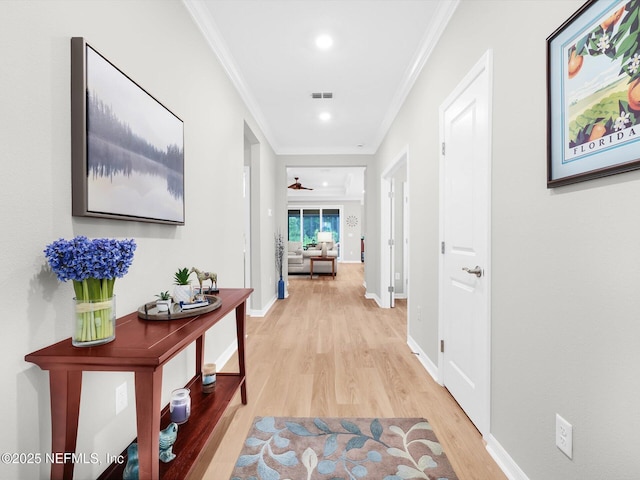 hallway featuring light wood-style flooring, baseboards, ornamental molding, visible vents, and recessed lighting