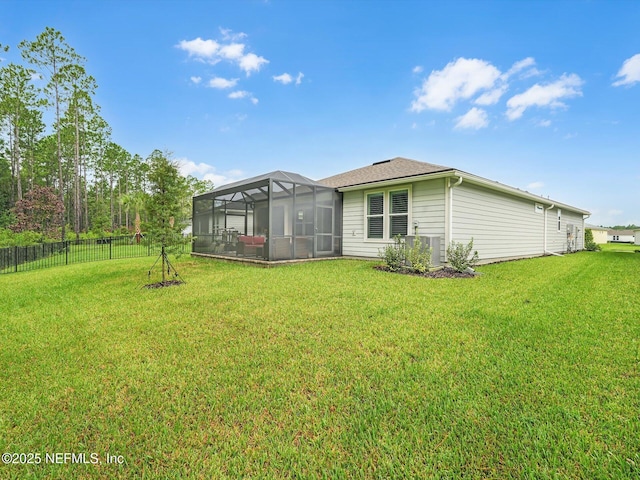 back of property featuring a lawn, fence, glass enclosure, and a shingled roof