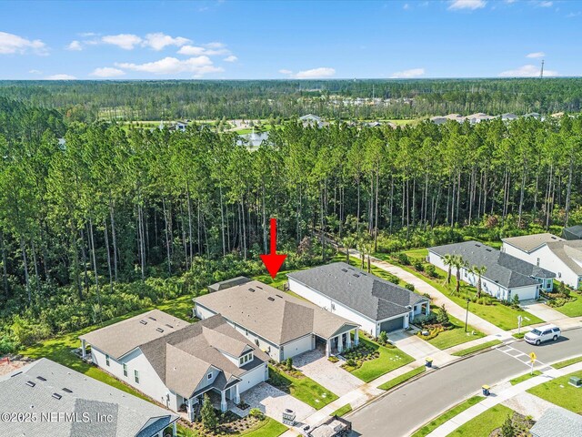 bird's eye view featuring a residential view and a wooded view