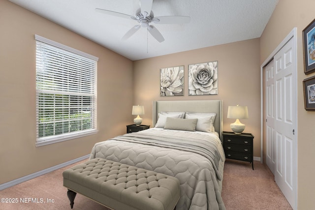 bedroom featuring ceiling fan, a closet, carpet flooring, and baseboards