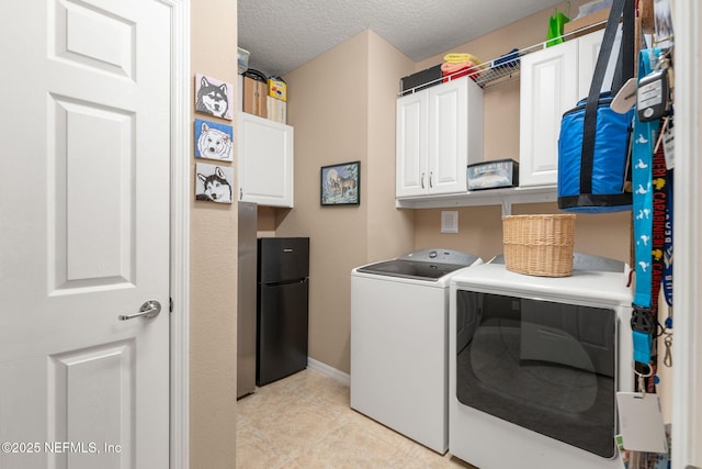 clothes washing area with cabinet space, washer and clothes dryer, light tile patterned floors, baseboards, and a textured ceiling