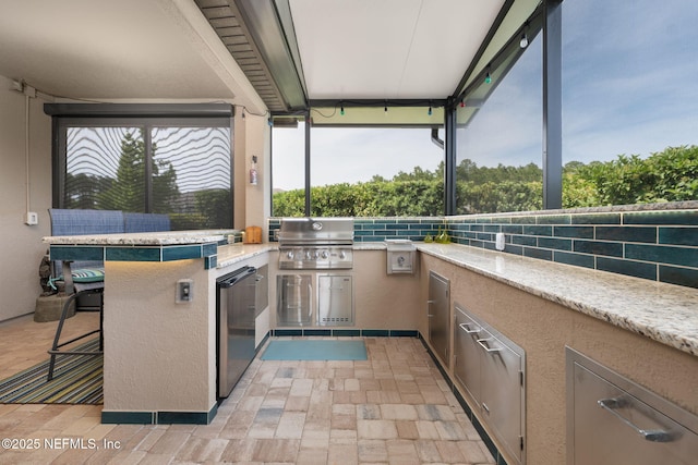 view of patio / terrace with an outdoor kitchen, area for grilling, and outdoor wet bar
