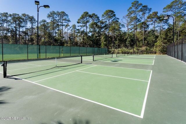 view of tennis court with fence and community basketball court