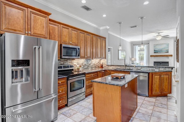 1104 Creekwood Way, Saint Johns, FL 32259 - kitchen featuring appliances with stainless steel finishes, a peninsula, brown cabinets, a center island, and backsplash
