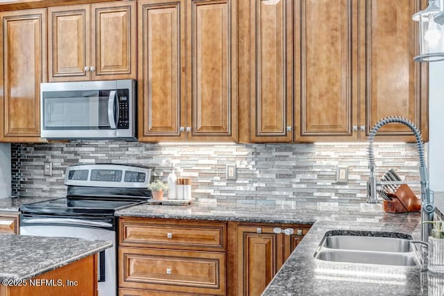 1104 Creekwood Way, Saint Johns, FL 32259 - kitchen with stainless steel appliances, brown cabinets, backsplash, and dark stone counters