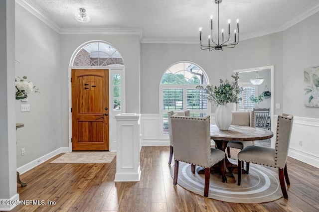 1104 Creekwood Way, Saint Johns, FL 32259 - dining room with a chandelier, hardwood / wood-style floors, crown molding, a textured ceiling, and ornate columns