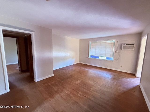 unfurnished room with baseboards, a wall mounted AC, and wood finished floors