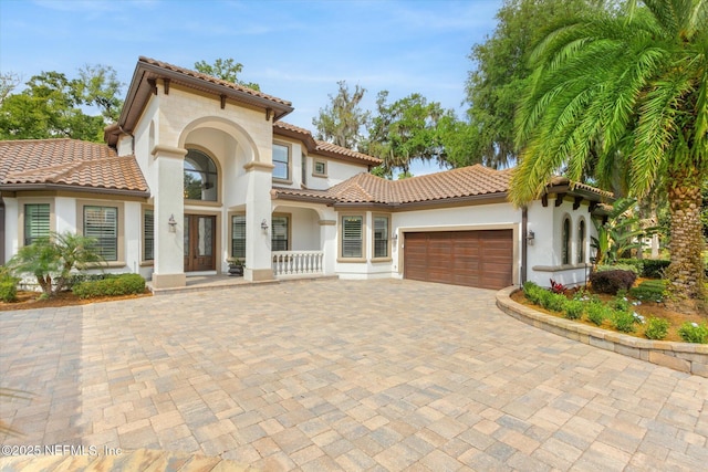 106 Villa Sovana Ct, Saint Johns, FL 32259 - mediterranean / spanish house featuring a tiled roof, stucco siding, decorative driveway, and a garage