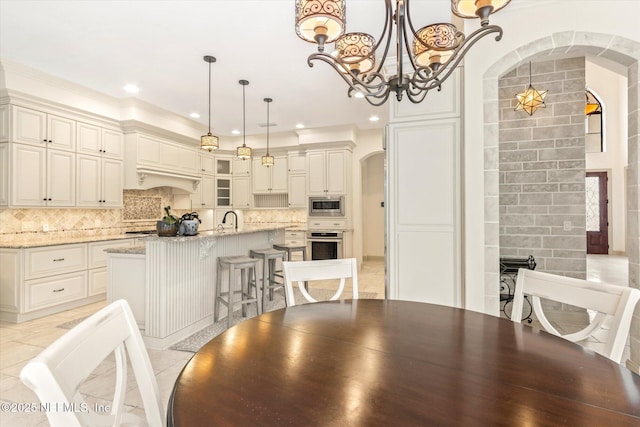 106 Villa Sovana Ct, Saint Johns, FL 32259 - dining area featuring arched walkways, crown molding, an inviting chandelier, and recessed lighting