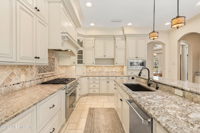 106 Villa Sovana Ct, Saint Johns, FL 32259 - kitchen featuring pendant lighting, stone tile floors, light stone counters, a sink, and stainless steel appliances