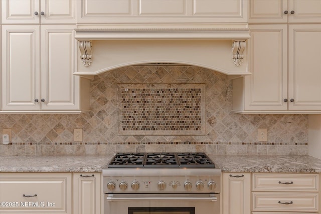 106 Villa Sovana Ct, Saint Johns, FL 32259 - kitchen featuring cream cabinetry, high end stainless steel range oven, light stone counters, and backsplash