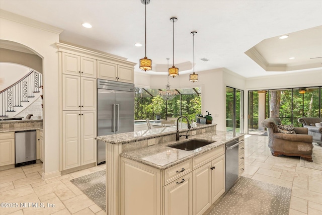 106 Villa Sovana Ct, Saint Johns, FL 32259 - kitchen with cream cabinets, a sink, open floor plan, a raised ceiling, and appliances with stainless steel finishes