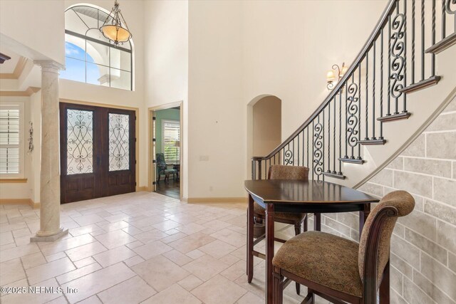 106 Villa Sovana Ct, Saint Johns, FL 32259 - foyer with stone tile flooring, baseboards, stairs, a towering ceiling, and arched walkways