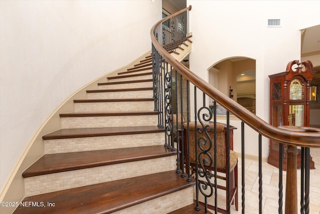 106 Villa Sovana Ct, Saint Johns, FL 32259 - staircase featuring a high ceiling, arched walkways, and visible vents
