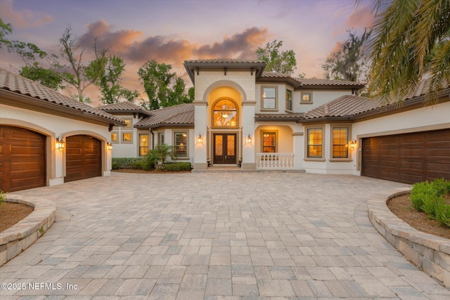 106 Villa Sovana Ct, Saint Johns, FL 32259 - mediterranean / spanish-style house featuring an attached garage, french doors, stucco siding, a tiled roof, and decorative driveway