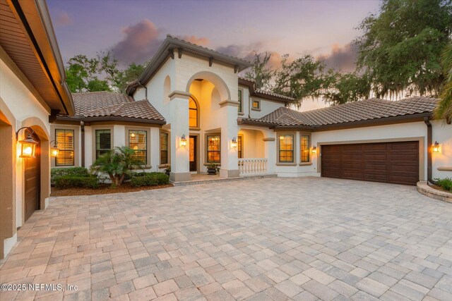 106 Villa Sovana Ct, Saint Johns, FL 32259 - mediterranean / spanish house with a tile roof, stucco siding, an attached garage, and decorative driveway