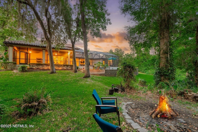 106 Villa Sovana Ct, Saint Johns, FL 32259 - yard at dusk featuring an outdoor fire pit and glass enclosure