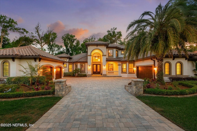 106 Villa Sovana Ct, Saint Johns, FL 32259 - mediterranean / spanish house featuring french doors, decorative driveway, a garage, stucco siding, and a tile roof
