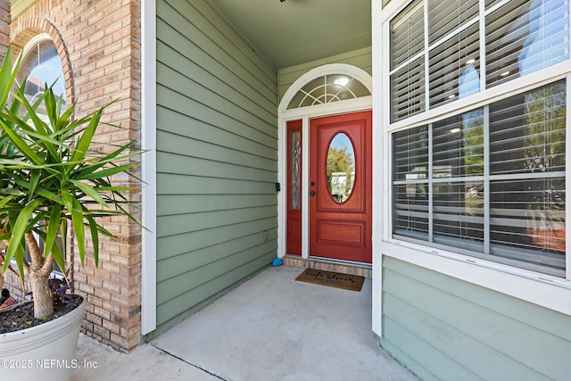 property entrance with brick siding and a porch