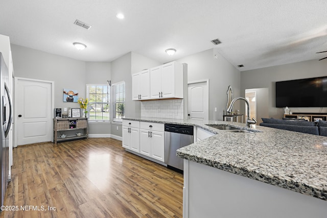 kitchen with wood finished floors, visible vents, stainless steel appliances, and a sink
