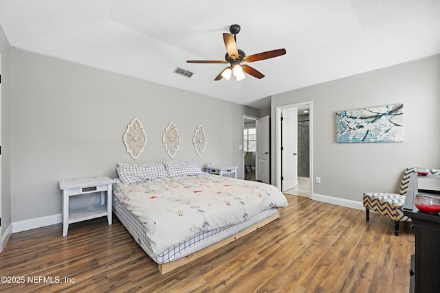 bedroom featuring baseboards, wood finished floors, visible vents, and ceiling fan