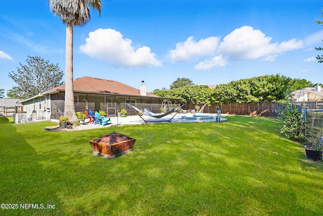 view of yard featuring a patio area, an outdoor fire pit, a fenced backyard, a fenced in pool, and a sunroom