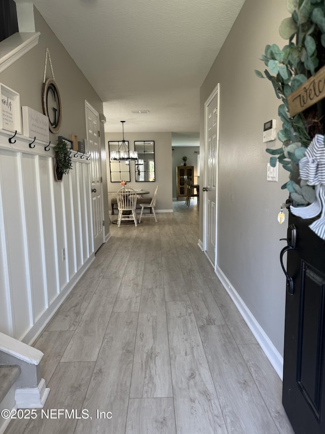 1500 Calming Water Dr Unit 5501, Fleming Island, FL 32003 - corridor featuring baseboards, an inviting chandelier, and wood finished floors