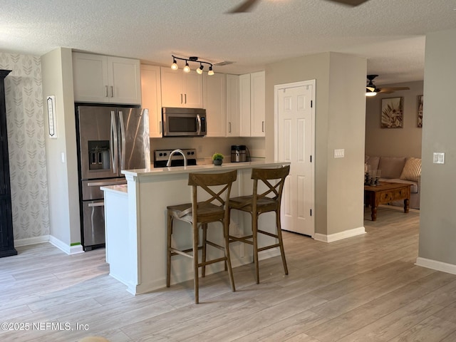 1500 Calming Water Dr Unit 5501, Fleming Island, FL 32003 - kitchen featuring light wood-style floors, appliances with stainless steel finishes, ceiling fan, and light countertops