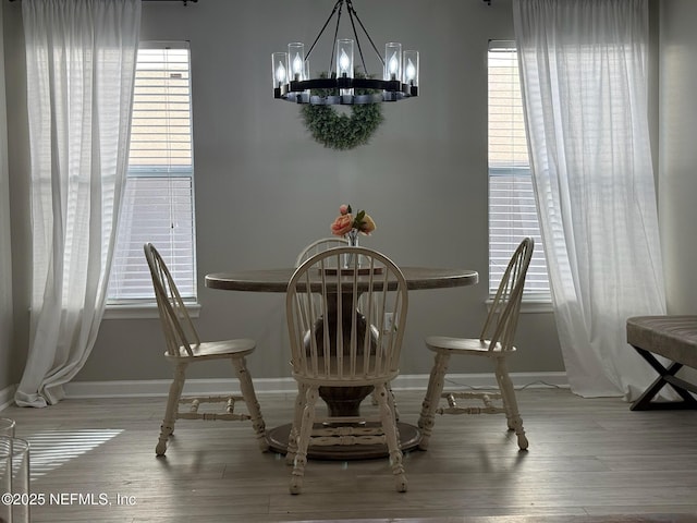 1500 Calming Water Dr Unit 5501, Fleming Island, FL 32003 - dining space with an inviting chandelier, baseboards, and wood finished floors