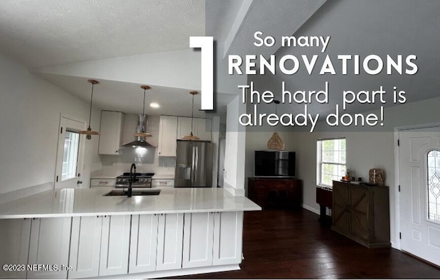 451 Whiting Ln, Atlantic Beach, FL 32233 - kitchen featuring a sink, stainless steel fridge, wall chimney exhaust hood, lofted ceiling, and dark wood-type flooring