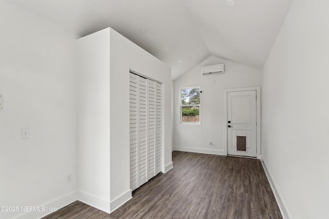 1407 Palmer Ter, Jacksonville, FL 32207 - unfurnished living room with wood finished floors, a wall mounted air conditioner, lofted ceiling, and baseboards
