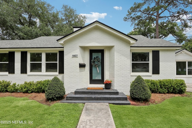 1407 Palmer Ter, Jacksonville, FL 32207 - bungalow-style home with a front lawn, brick siding, and roof with shingles