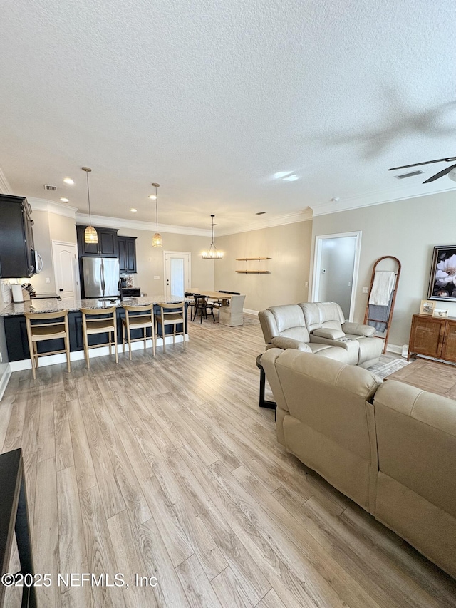 6128 Copper Ridge Cir, Macclenny, FL 32063 - living room featuring crown molding, a textured ceiling, visible vents, and light wood-type flooring