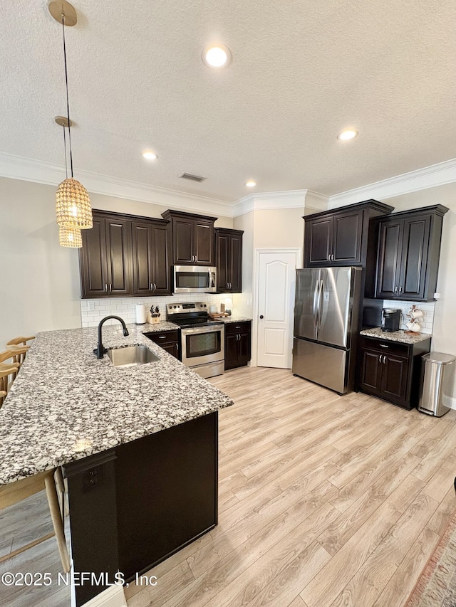 6128 Copper Ridge Cir, Macclenny, FL 32063 - kitchen with a peninsula, light wood-style floors, a textured ceiling, a sink, and appliances with stainless steel finishes