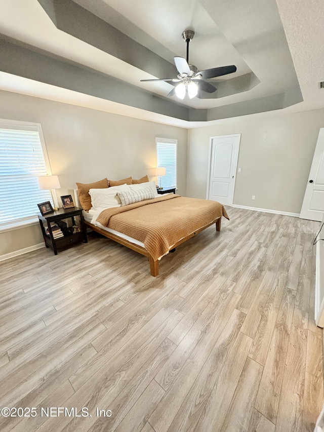 6128 Copper Ridge Cir, Macclenny, FL 32063 - bedroom featuring visible vents, light wood-style floors, baseboards, a raised ceiling, and a ceiling fan