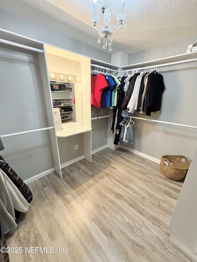6128 Copper Ridge Cir, Macclenny, FL 32063 - walk in closet with visible vents, wood finished floors, and an inviting chandelier